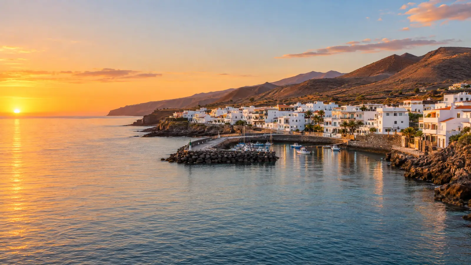 Playa San Juan, en Guía de Isora, con casas blancas junto a la costa al atardecer (recreación ilustrativa)